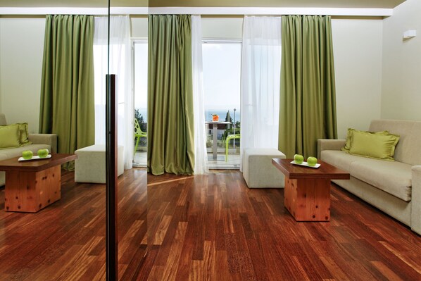 A modern living room with two sofas, wooden coffee tables, and green curtains. - Boutique Hotel Bol (Bol)