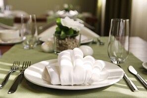 A dining table set with a white plate, silverware, and a glass. - Boutique Hotel Bol (Bol)