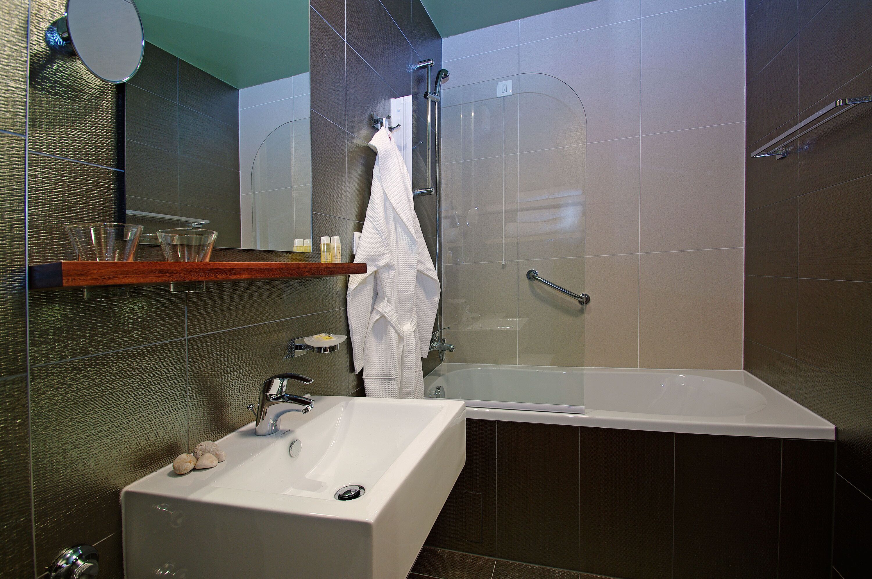 Une salle de bain moderne avec une baignoire, un lavabo et une douche à l’italienne.