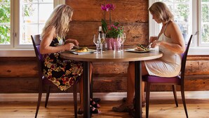 A wooden cabin interior with a dining table, two chairs, and a large wooden eagle decoration on the wall. - Stor-Elvdal Hotell (Stor-Elvdal)