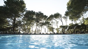 A swimming pool with clear water, surrounded by trees and lounge chairs. - Hotel Bordoy Continental Valldemossa (Valldemossa)