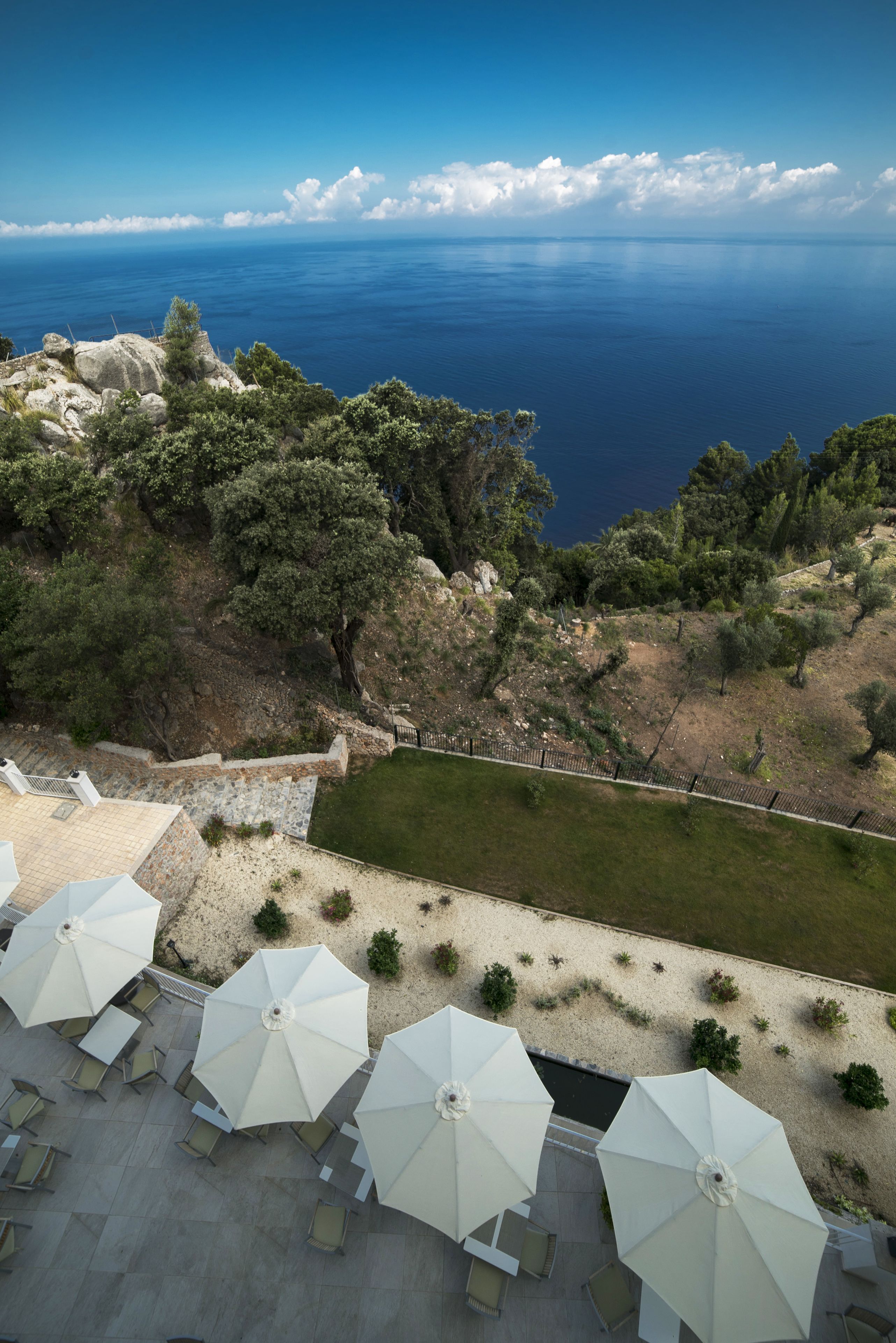 A terrace with outdoor seating and a view of the sea.