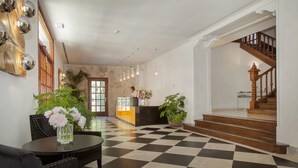 A lobby with a checkered floor, a reception desk, a staircase, and a seating area with a vase of flowers. - Hotel Bordoy Continental Valldemossa (Valldemossa)