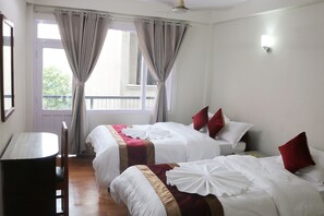 A hotel room with two beds, a table, and a chair. - Om Tara Guest House (Kathmandu)