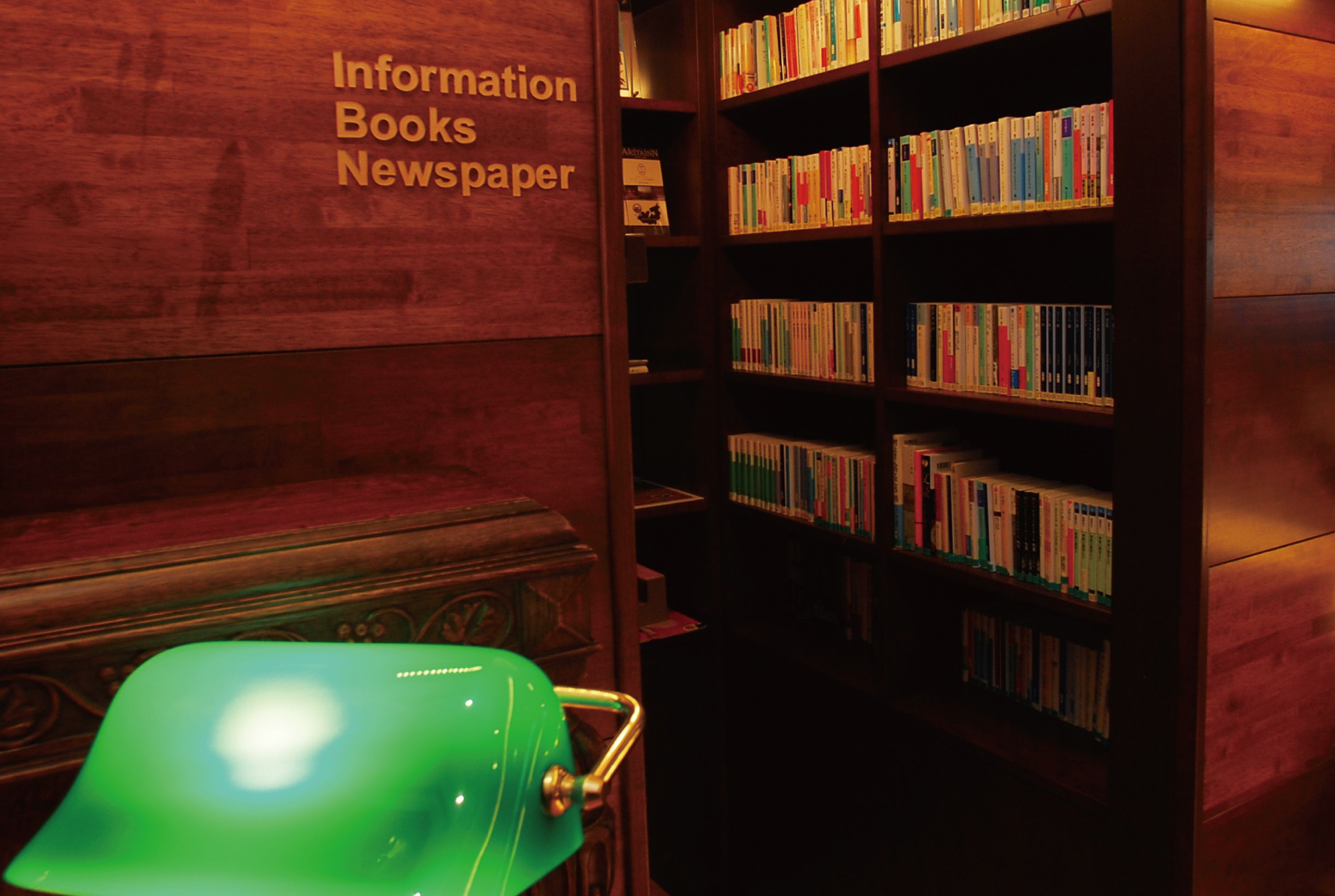 A library with bookshelves and a green chair.