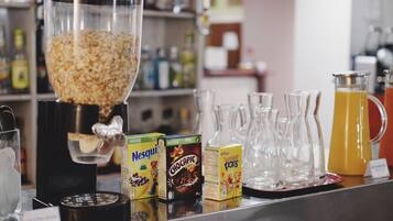 A cereal bar with various boxes of cereal, a coffee machine, and several glass pitchers on a counter.