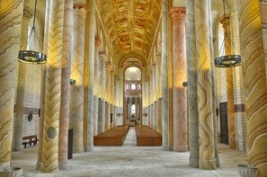 A long, narrow hall with high, marble columns and a central aisle. - Hôtel de France (Saint-Savin)