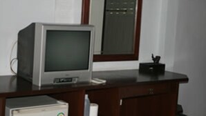 Una habitación con un escritorio de madera, un monitor antiguo y un ordenador de escritorio.