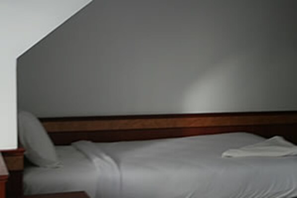 A bedroom with a wooden headboard, a single bed, and a nightstand. - Jinda Resort (Ko Chang)