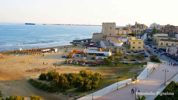 Une ville côtière dotée d’une plage, d’un édifice ressemblant à un château, et d’un mélange de bâtiments résidentiels et commerciaux.