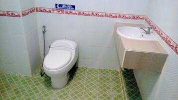 A small bathroom with a toilet, sink, and a shower.