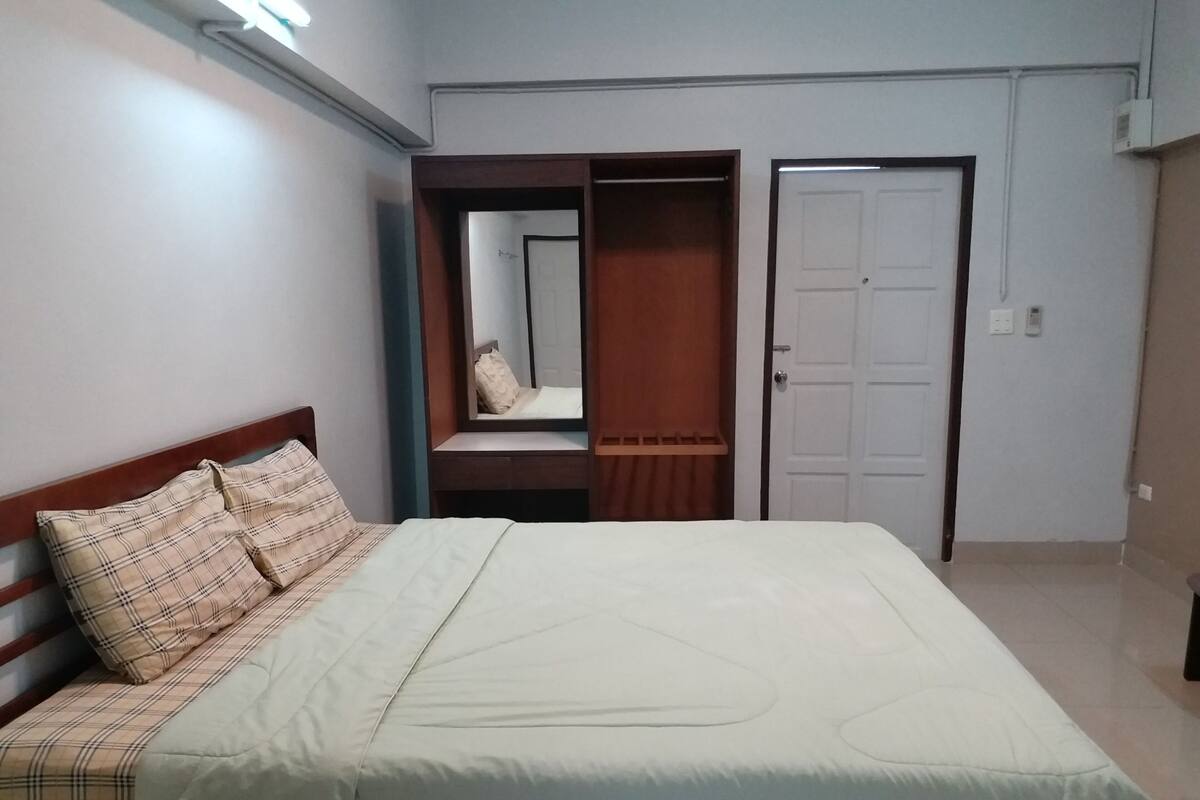 A bedroom with a bed, a wardrobe, and a door.