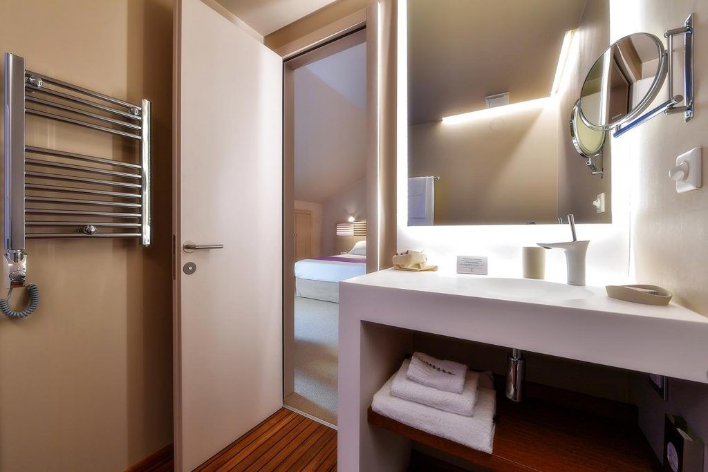 Ein modernes Badezimmer mit Handtuchhalter, Spiegel und Waschbecken.