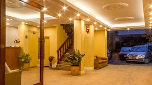 A hotel lobby with a staircase, potted plants, and a reception desk. - Hotel Jagat (Kathmandu)