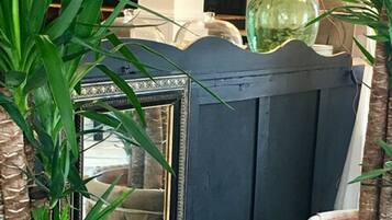 Un mueble azul con un espejo, una lámpara verde y plantas verdes.