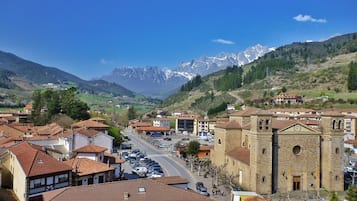 Un pueblo con arquitectura tradicional, una calle central y una cadena montañosa al fondo.