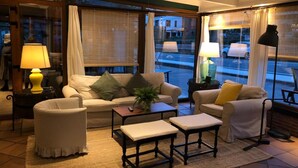 A cozy living room with a sofa, armchairs, a coffee table, and a lamp.