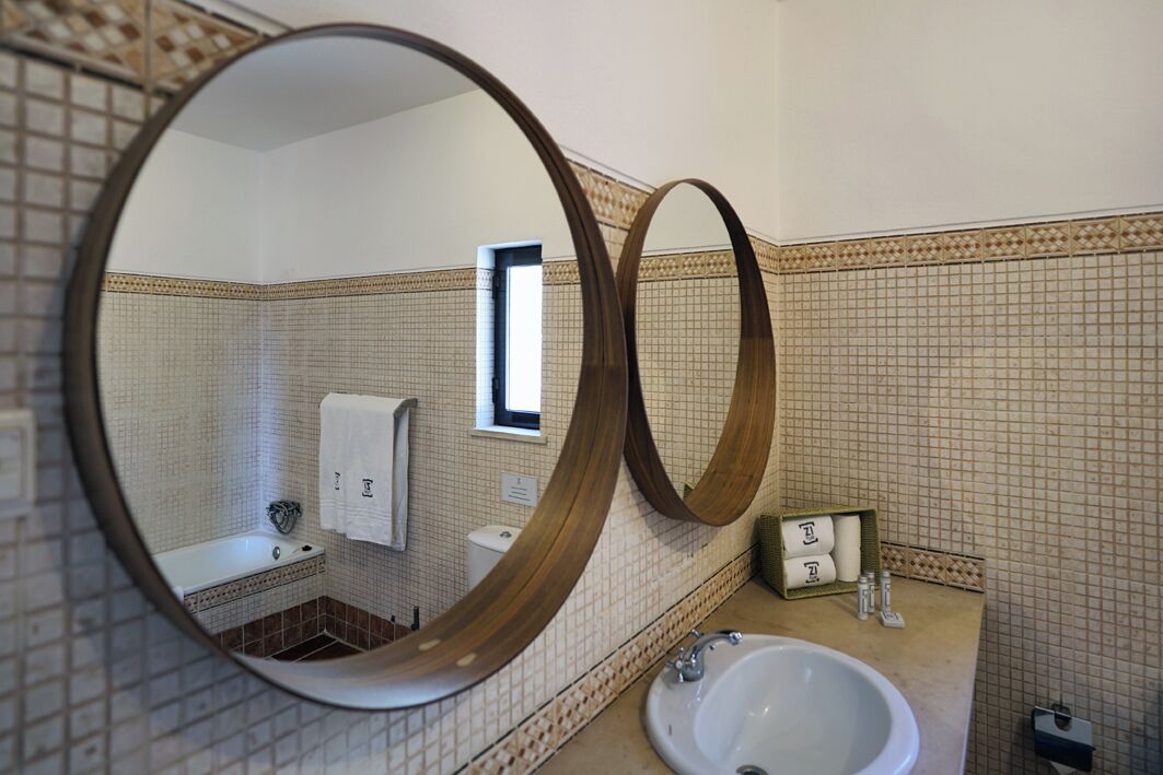 A bathroom with a large mirror, a sink, and a toilet.