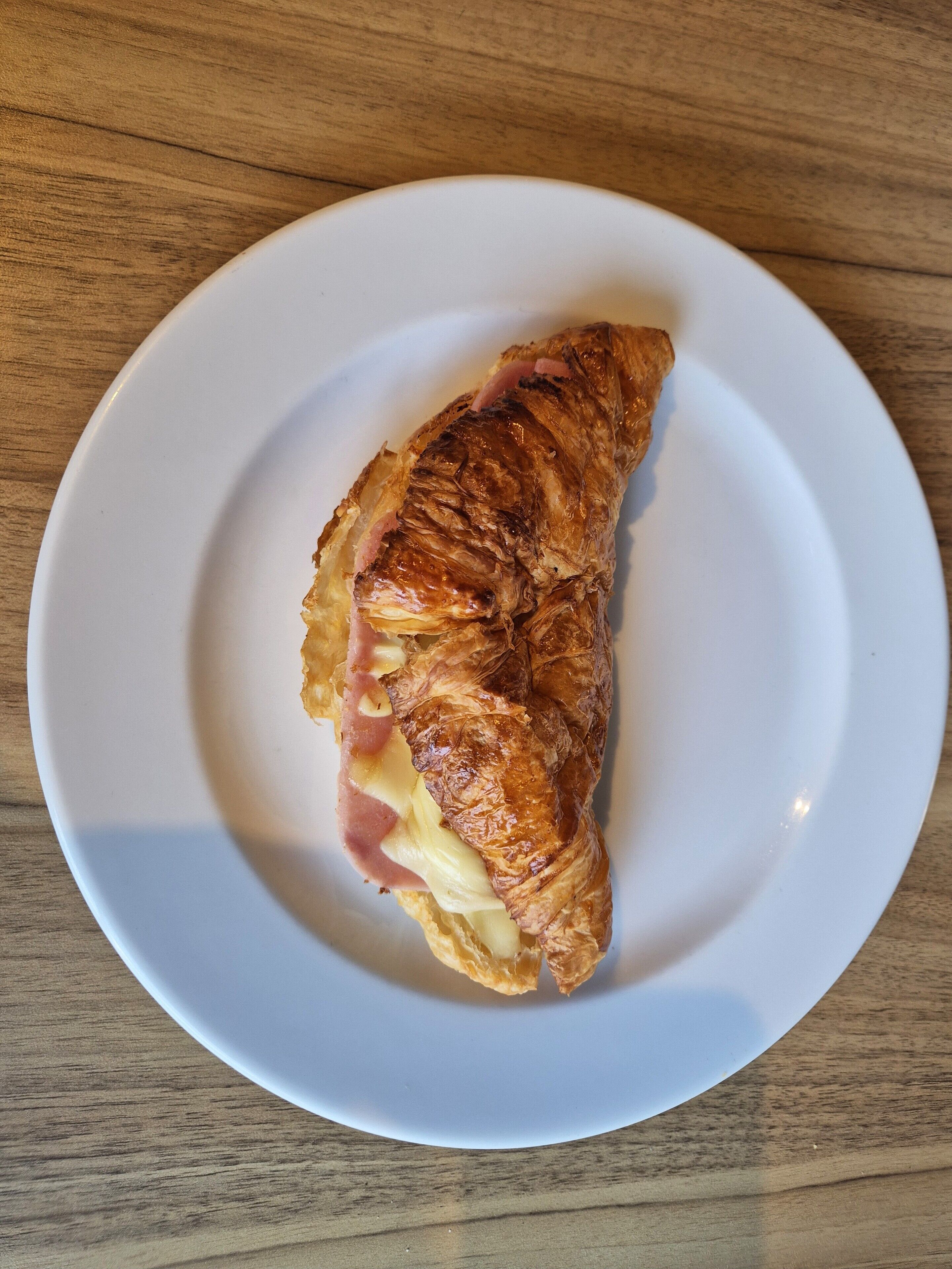 A croissant on a white plate.