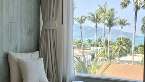 Un dormitorio con vista a palmeras y una playa.