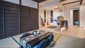 Een traditionele Japanse kamer met tatami vloeren, een lage tafel met een bloemenloper en een schuifdeur.