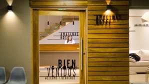 A reception area with a wooden interior, a staircase, and a sign that reads "Bien Venidos" welcoming guests. - Amalinas Hotel (Villa San Lorenzo)