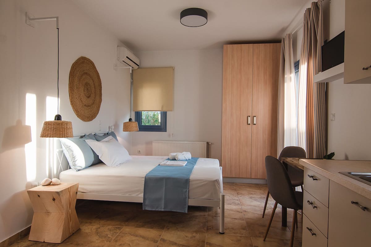 Ein Schlafzimmer mit einem Bett, Nachttischlampen, einem Holzschrank, einem Schreibtisch und einem Stuhl.
