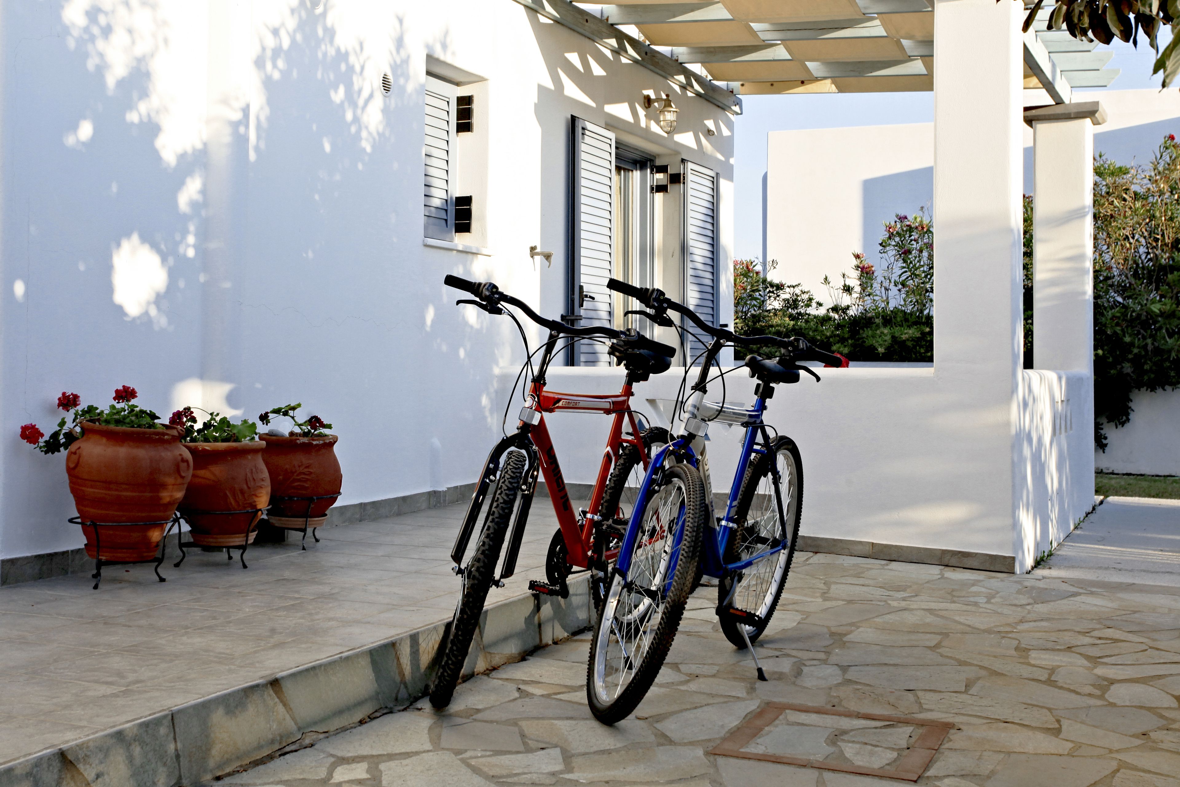 Un bâtiment blanc doté d’un patio couvert. Deux vélos sont garés sur le patio.