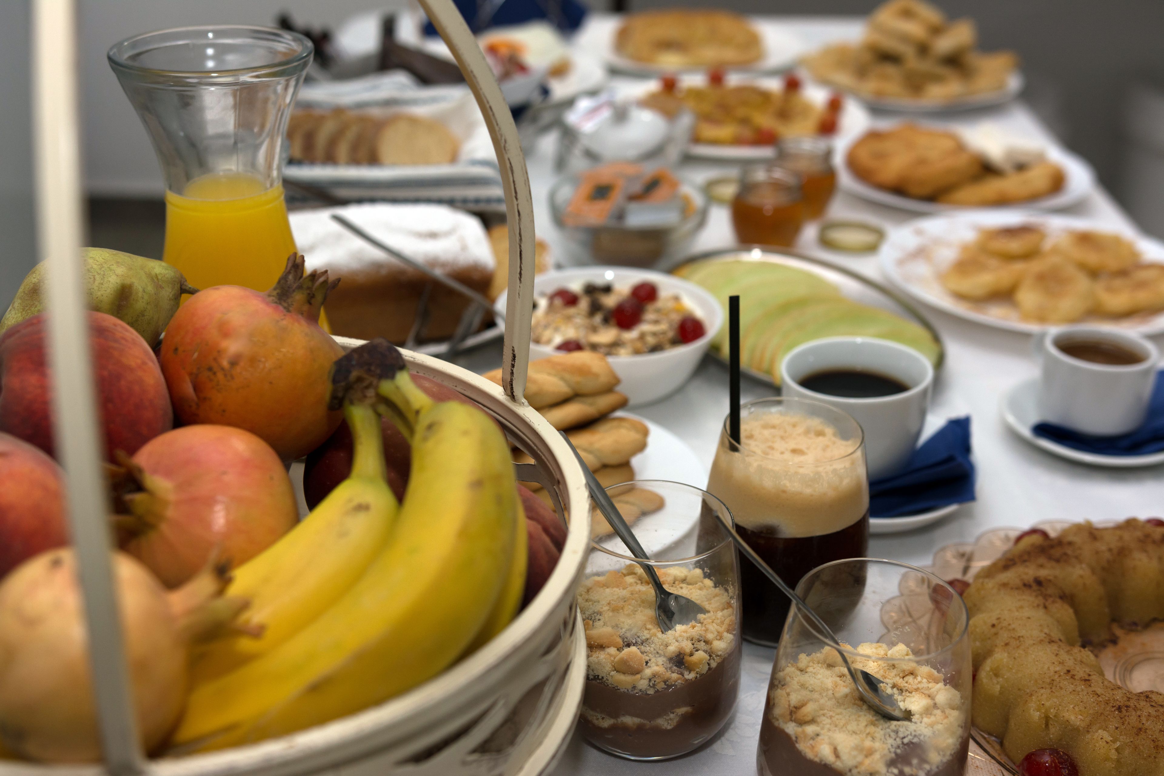 A table with various breakfast items including fruits, pastries, and beverages.
