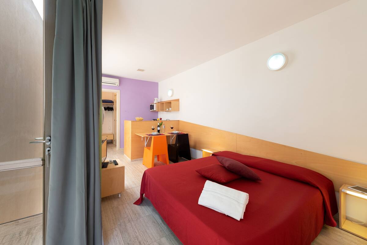 Ein Hotelzimmer mit Bett, Schreibtisch, Stuhl, Kleiderschrank und Bad.