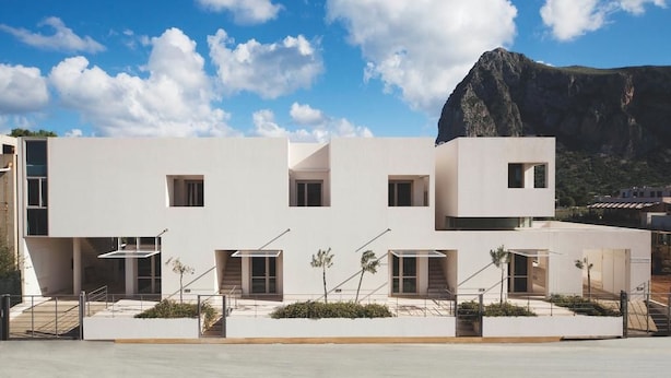 Un bâtiment moderne doté d’un toit plat, de nombreuses fenêtres et d’un escalier menant à un étage supérieur.