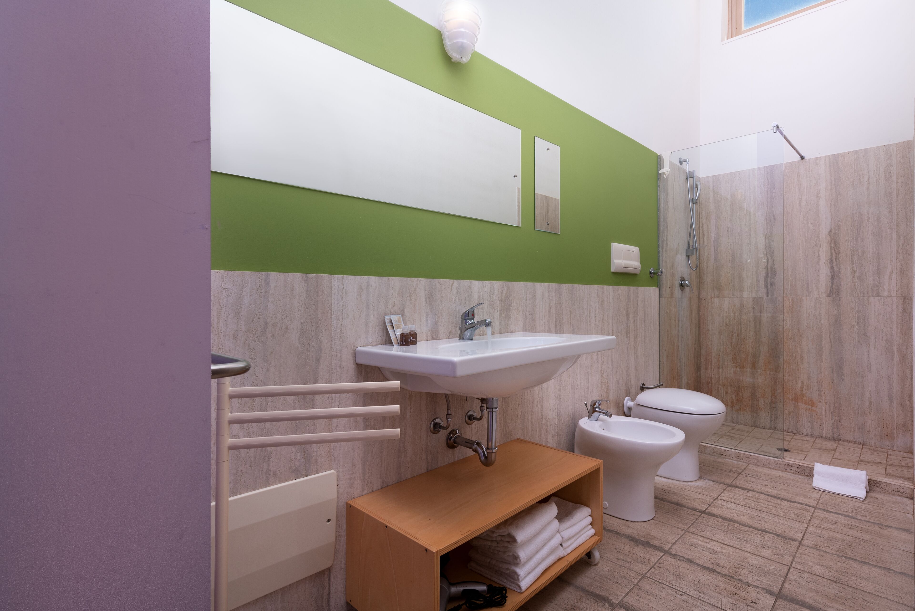 Et moderne badeværelse med en hvid vask, toilet og bruser.