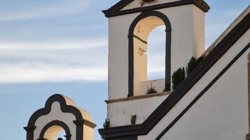 A building with a bell tower and a nest on top.