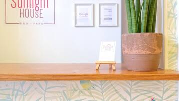 A reception desk with a 'Sunlight House' sign, framed awards, and a potted plant.