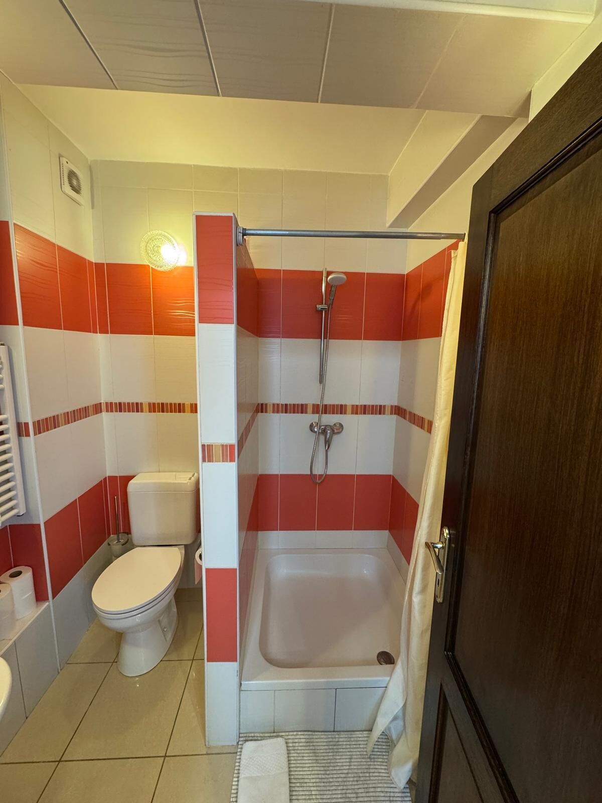 A bathroom with a toilet, a bathtub, and a shower.