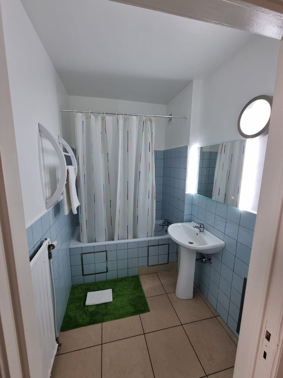 Un baño con bañera, lavamanos y cortina de ducha.