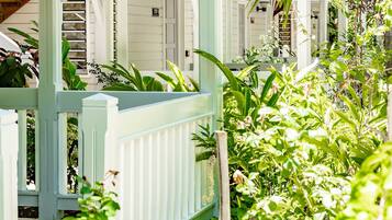 Surrounded by lush greenery, this outdoor space offers a serene escape with a wooden ceiling and railings.