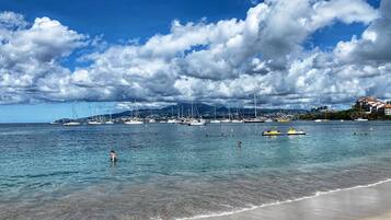 On the beach, white sand, sun-loungers, beach umbrellas