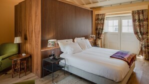 Une chambre bien rangée, avec un lit, des tables de chevet, une lampe et une chaise.