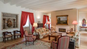 A traditional living room with a fireplace, floral upholstery, and classic wooden furniture.