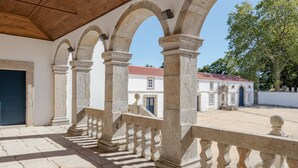Un espace extérieur abrité, doté d’arches en pierre et d’un plafond en bois.