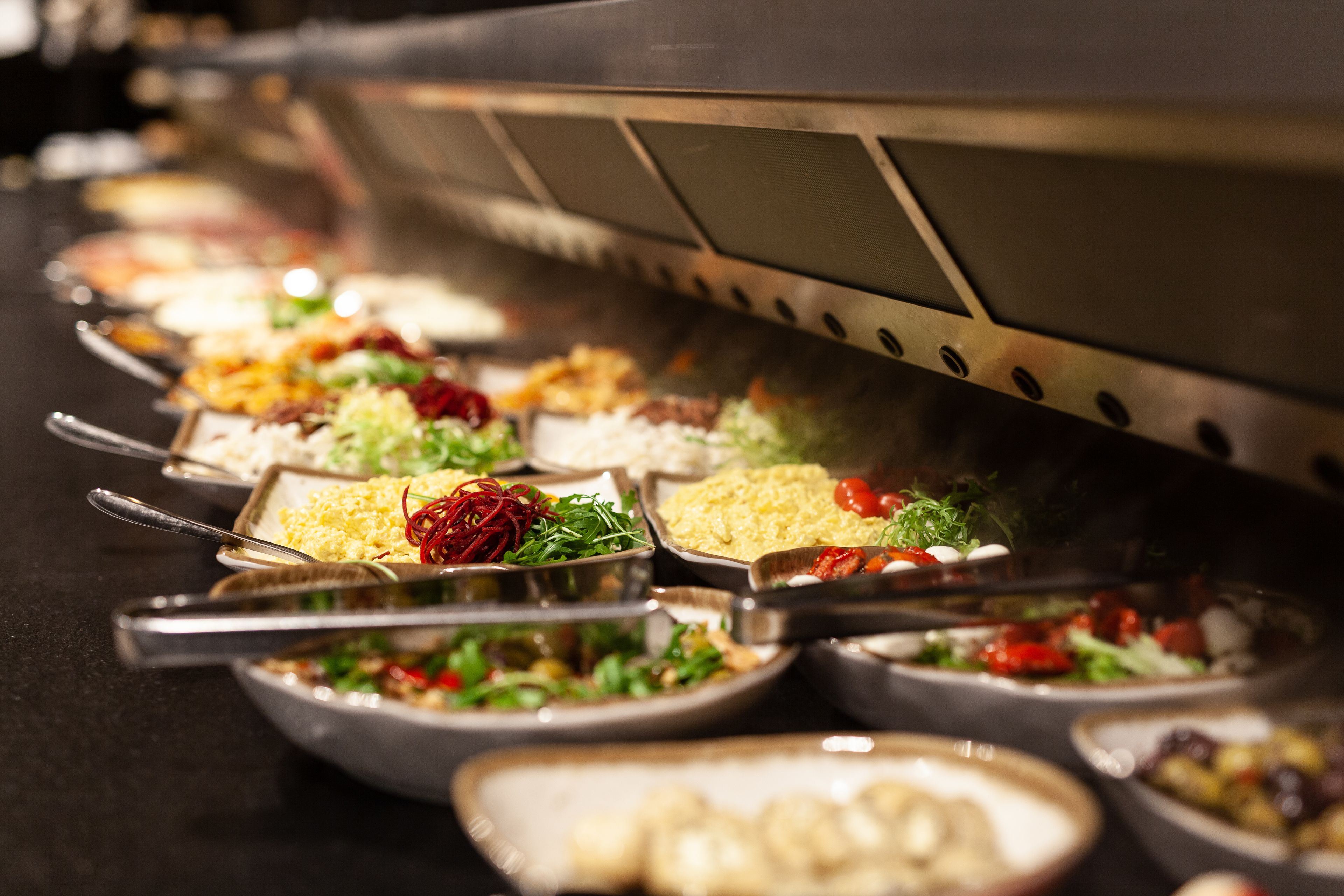 A buffet with various dishes and utensils.