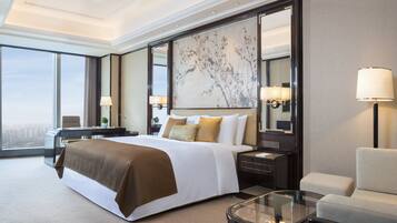 Une chambre d’hôtel spacieuse, dotée d’un grand lit, d’un coin salon, d’un bureau et offrant une vue sur la ville.