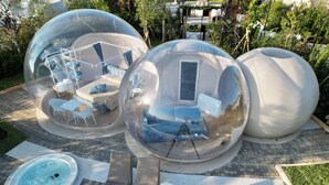 Estructuras esféricas transparentes con asientos y un jacuzzi.