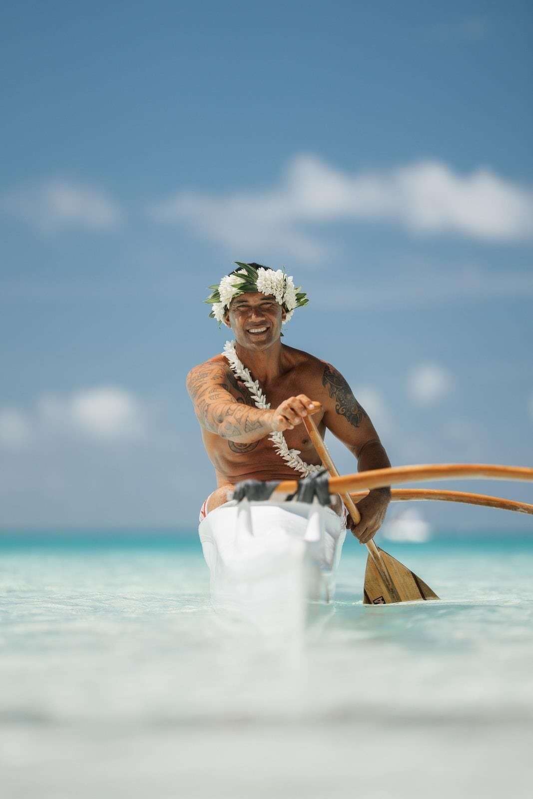 A person paddling a boat on a beach.