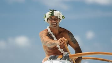 A person paddling a boat on a beach.
