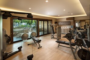 A gym with exercise equipment, a large window, and a view of the outdoors.