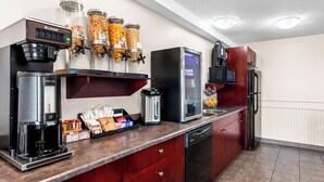 Une cuisine moderne équipée d’une machine à café, d’un réfrigérateur et d  ’un four à micro-ondes.