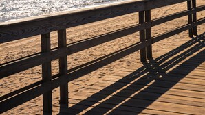 Un paseo marítimo de madera que conduce a una playa, con vista despejada al océano.