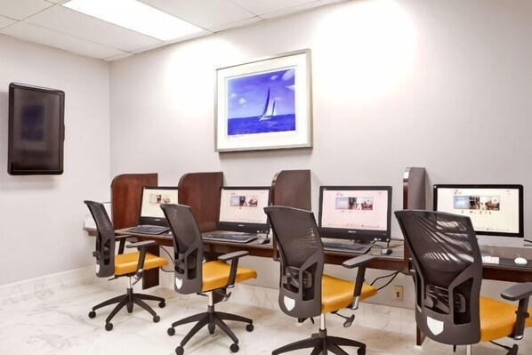 A conference room with four computer workstations, each with a monitor, keyboard, and chair. - Hilton Miami Downtown (Miami)